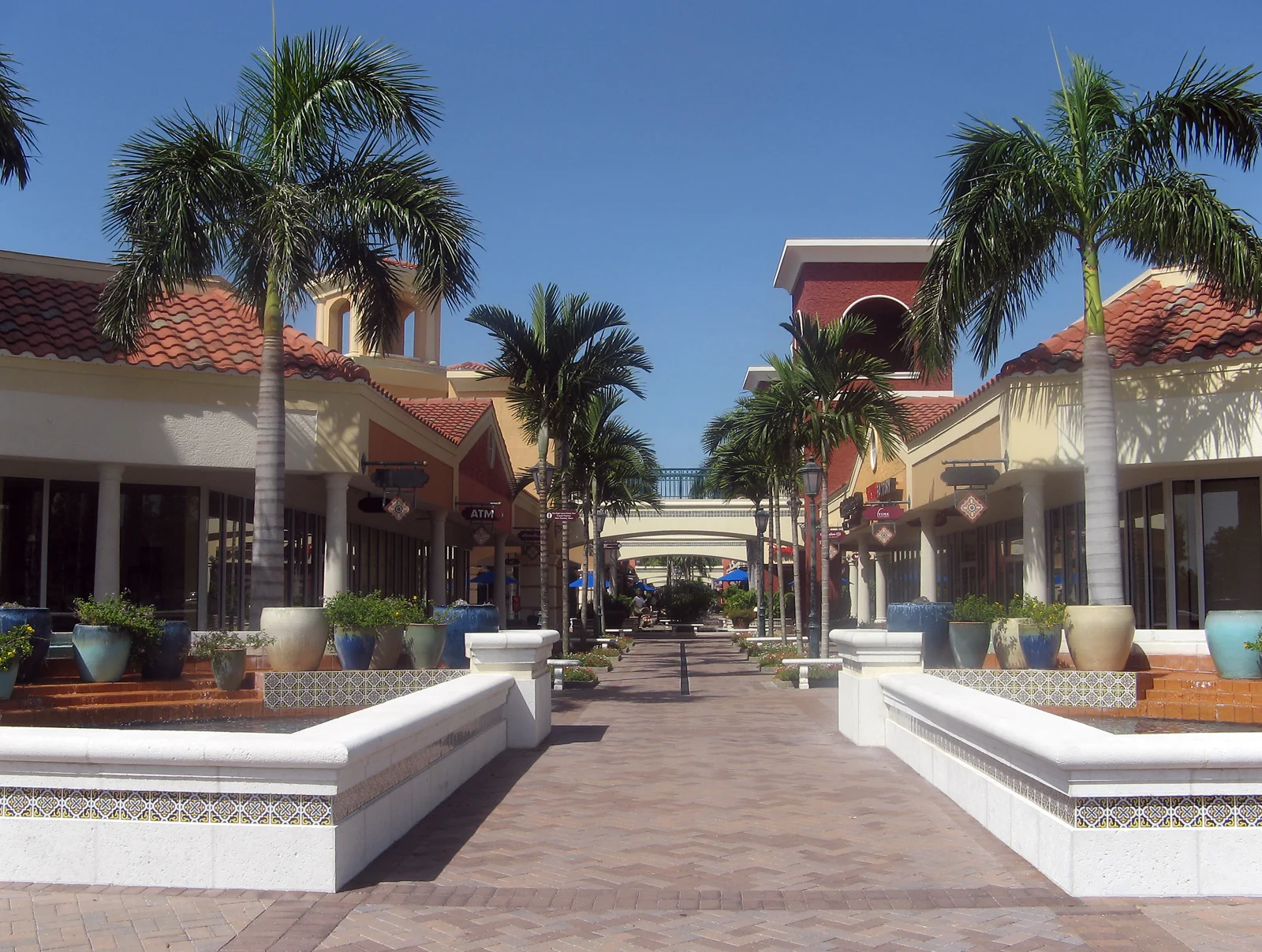 Palm-lined pedestrian courtyard and storefronts at Miromar Outlets in Estero